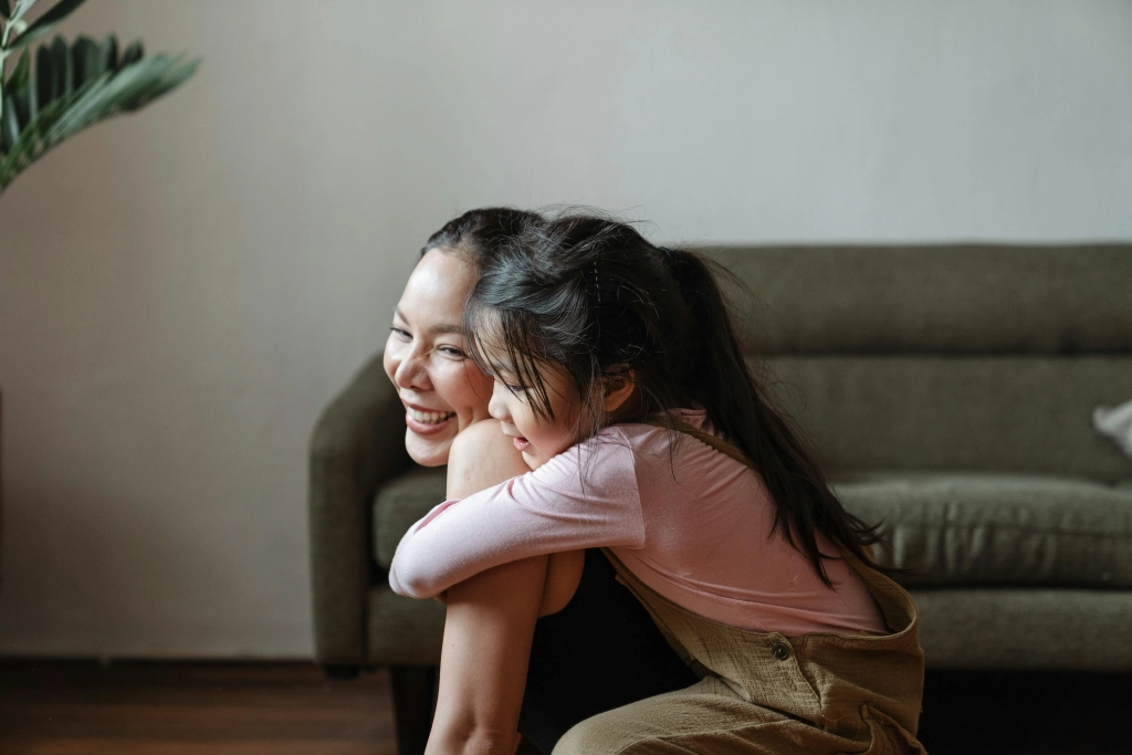 Asian mom and daughter share a playful moment in their Cochrane & Calgary home - Family Counselling with Najwa Zahr.