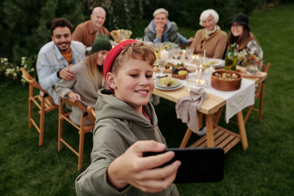 Joyful multi-cultural family enjoying an outdoor picnic in Cochrane and Calgary, capturing a moment of happiness through a selfie.