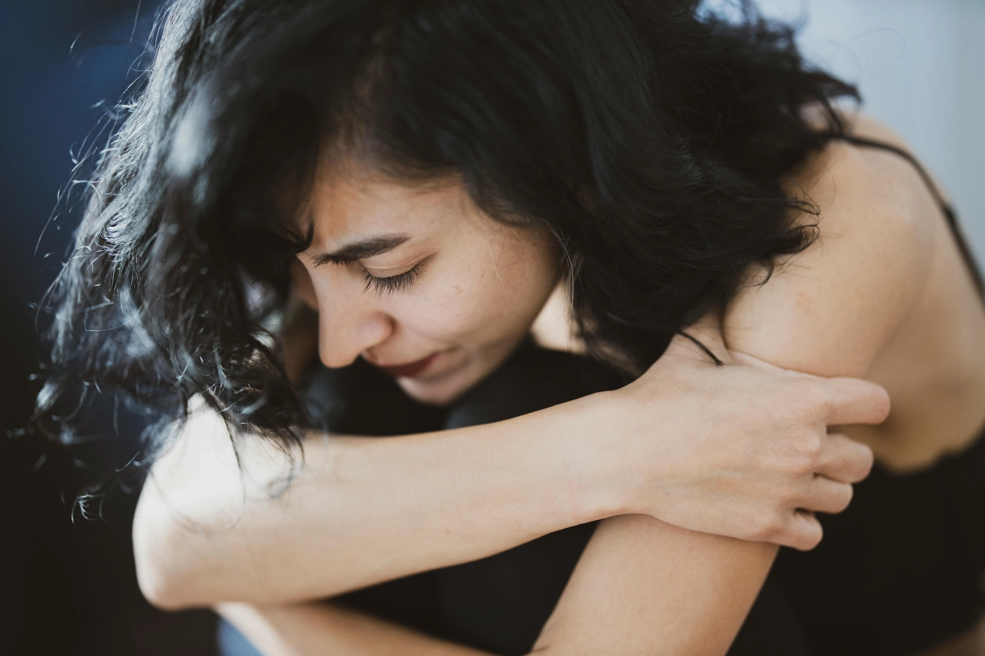 anxiety woman with black hair in fetal position