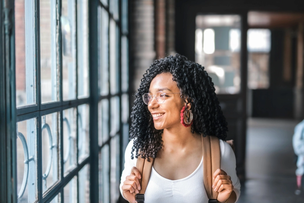 Black woman alone smiling with backpack